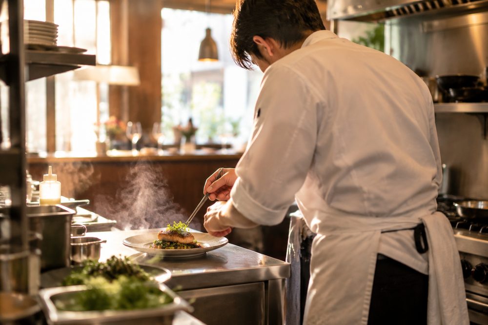 Chef plating a dish in the open kitchen